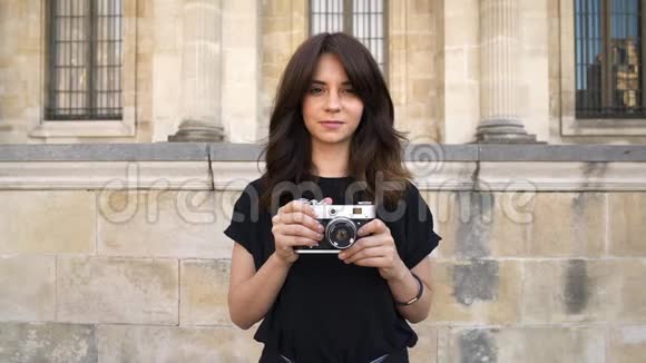 年轻女子在巴黎旧建筑背景下拍摄复卷镜头视频的预览图