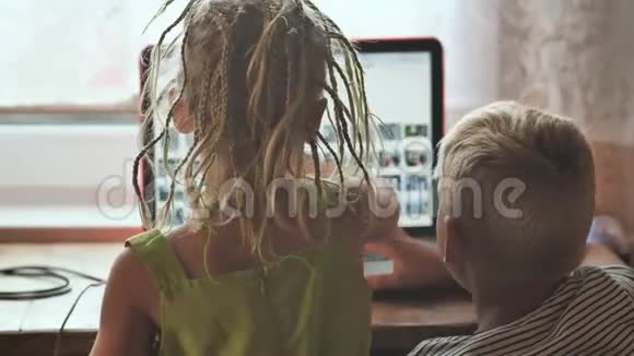 孩子们正在笔记本电脑上浏览照片视频的预览图