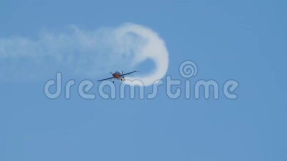 带有螺旋桨的飞机在缓慢的运动中画出天空中的烟雾图案显示回路视频的预览图