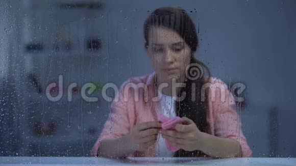 雨天抱着未出生孩子的粉红色袜子的妇女烦躁不安不孕问题视频的预览图