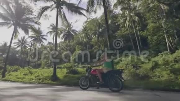 老人骑摩托车在阳光的背景下上路成熟的男人骑摩托车绿树成荫视频的预览图