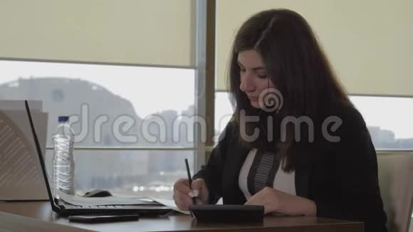 厌倦工作的孕妇在办公室里喝水和踩她的胃视频的预览图