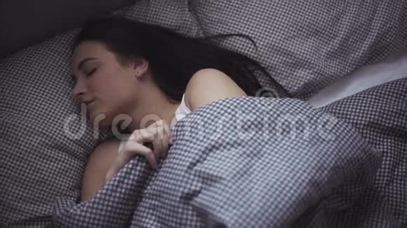 20多岁的女性早上在床上醒来女孩睡觉后正在伸展身体视频的预览图