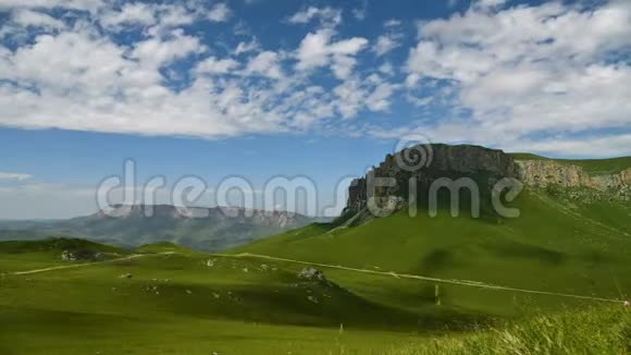 一个美丽的绿色高地的时间推移白天的岩石高原和云层和阴影的夏季景观视频的预览图