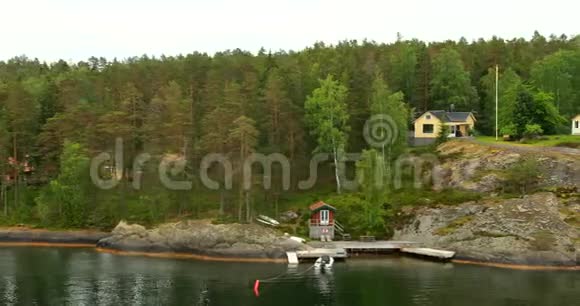 夏季多云天气岛上海岸的许多瑞典木制桑拿木屋视频的预览图
