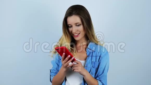 年轻漂亮性感的金发女郎在智能手机上接听电话她听到的消息使她对孤立的白色ba感到紧张视频的预览图