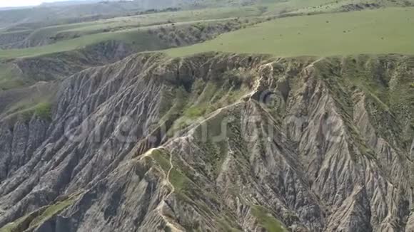 空中无人机观绿色沙漠高原全景陡峭的岩山视频的预览图