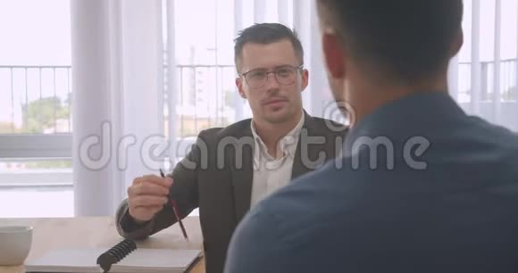 有吸引力的戴眼镜的商人在办公室进行工作面试的特写镜头视频的预览图