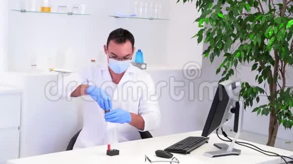在办公桌前穿着白大褂的男实验室工作人员视频的预览图
