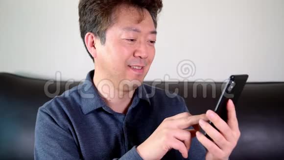 亚洲中年男性试图在手机上读到一些东西视频的预览图