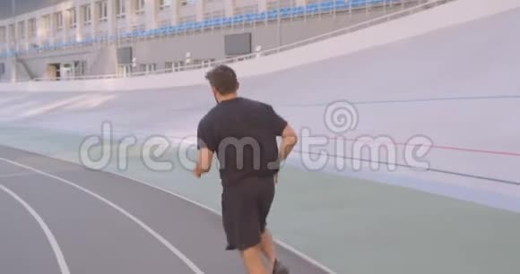 在城市户外运动场上慢跑的成年白种人运动男性跑步者的运动后景肖像视频的预览图