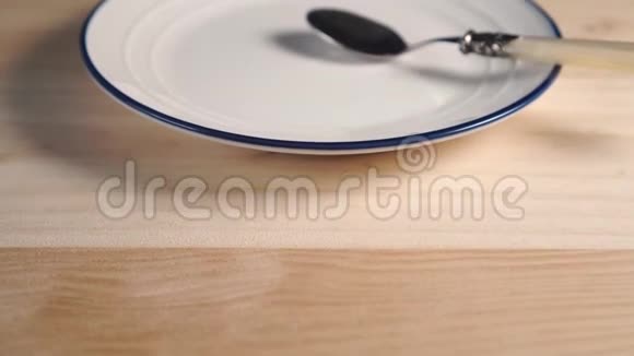 一个白色的盘子上面有蓝色的条纹上面有一个甜点勺子视频的预览图