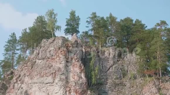 陡峭悬崖的全景人在山顶上挥动双手在悬崖下的船上视频的预览图