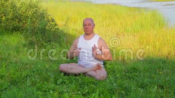 一个中年人早上在湖边做呼吸瑜伽和冥想视频的预览图