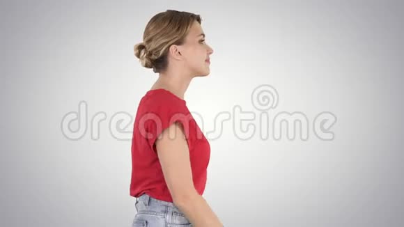 穿牛仔裤和t恤穿渐变背景的会走路的女人视频的预览图