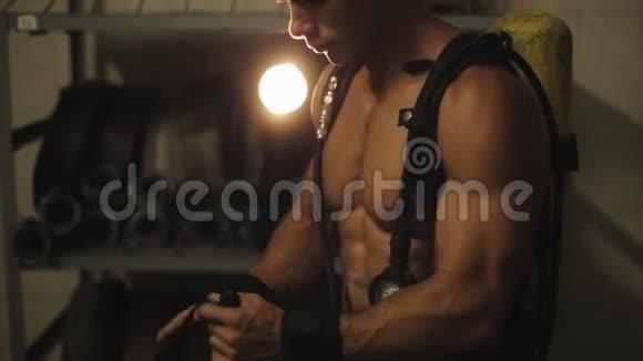近景穿着带压力表的氧气罐的无衫帅哥戴上氧气面罩明亮的投影仪视频的预览图