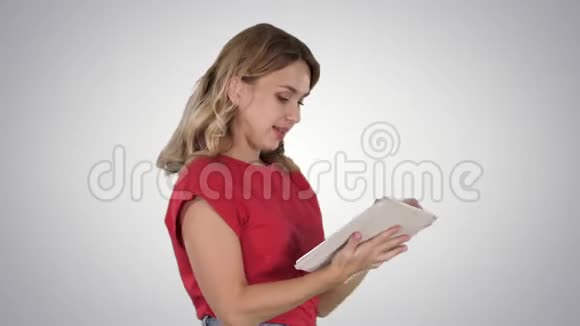 穿红色t恤的女人在梯度背景上使用平板电脑视频的预览图