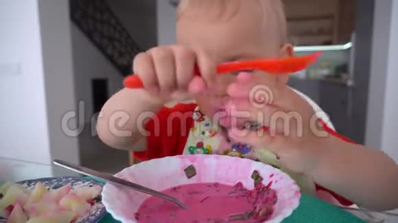 幼儿男孩用两个勺子吃甜菜根汤和土豆万向节运动视频的预览图
