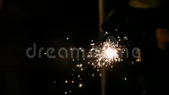 燃烧火花机的特写在黄昏喜庆的新年气氛中闪耀着明亮的金色火花视频的预览图