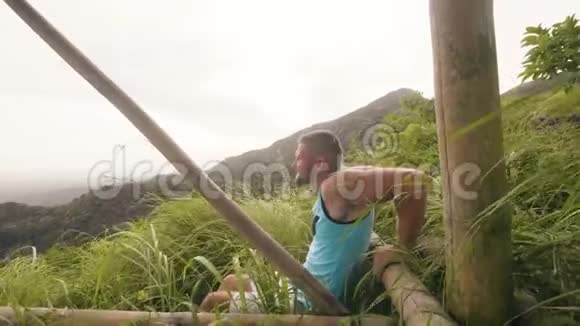 帅哥在青山和热带高地景观上做向上运动健美运动员训练促进手臂视频的预览图