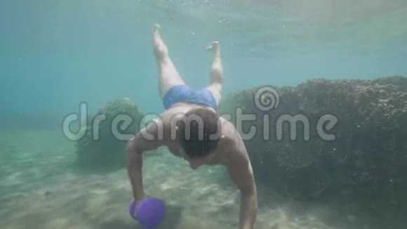 水下的年轻运动员正在用哑铃做一套练习视频的预览图