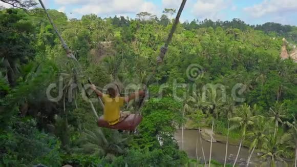 小男孩在热带地区荡秋千巴厘岛旅游理念视频的预览图