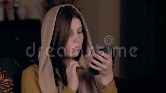 一位年轻漂亮的基督教妇女头上戴着头巾外表是高加索人坐在扶手椅上记录着一张视频的预览图