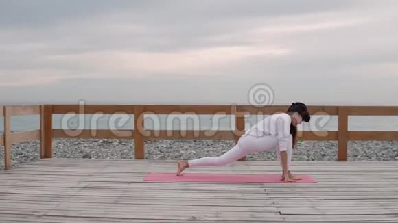灵活的女人在海上的新鲜空气中做瑜伽视频的预览图
