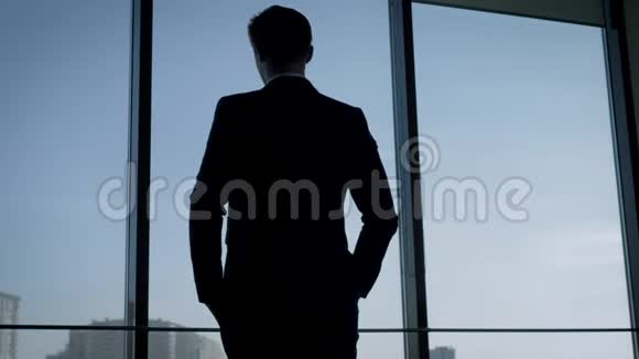 西装革履站在办公室看窗外的商人的后景视频的预览图
