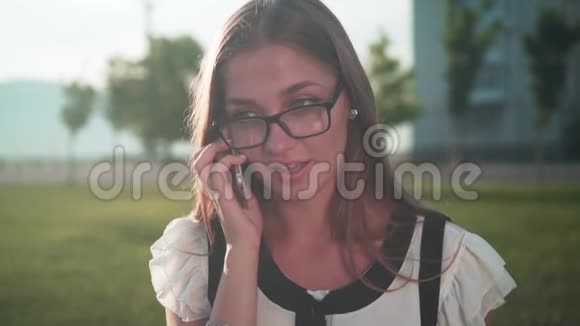 商务女性穿着白色衬衫和眼镜通过电话交谈女孩对对话者漠不关心和令人畏惧视频的预览图