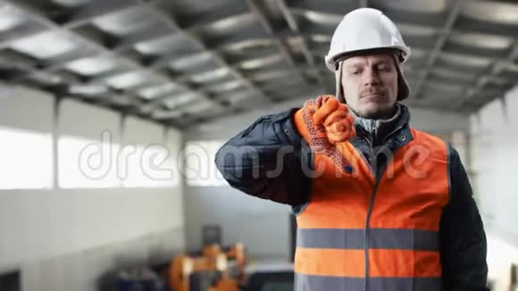 戴着安全帽穿着工作服的胡子和胡子正站在机库中间对着镜头竖起大拇指视频的预览图