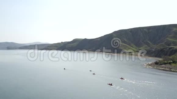 群彩皮艇漂浮在海上海岸海岸上的山脉视频的预览图