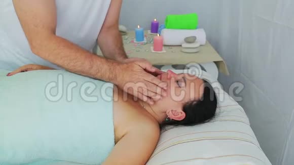 一位男性美容师给一位女性客户在一家水疗沙龙做面部按摩视频的预览图