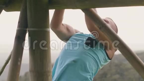 在热带高地景观的水平杆上进行健身男子训练运动员在拉视频的预览图