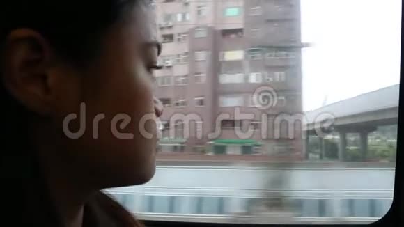 一个年轻悲伤的女人坐在火车上透过窗户看着视频的预览图