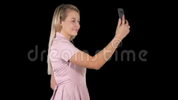 年轻的美女在手机上自拍阿尔法频道视频的预览图