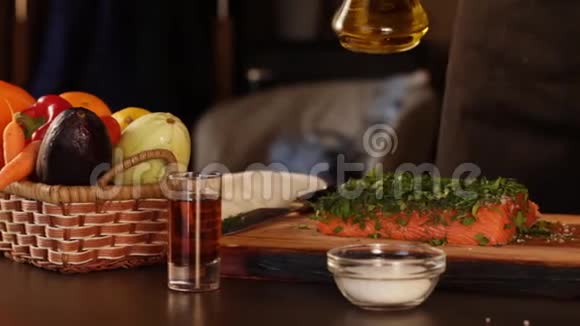 一大块生三文鱼片撒上盐和切碎的草药厨师用橄榄油把它洒出来视频的预览图