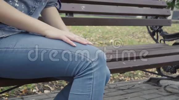 站在长凳上的女人感到公园里膝盖剧痛骨关节炎受伤视频的预览图