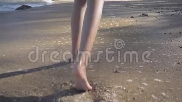 亚洲女孩的腿悠闲地走在海滩上海浪在海岸上拍打视频的预览图