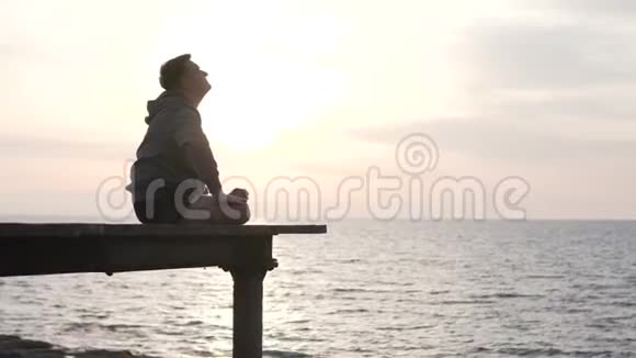 一个男人在日落的海面上练习瑜伽视频的预览图