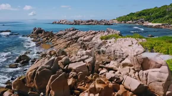 鸟瞰独特的海岸线与自然花岗岩巨石在遥远的天堂如海滩隐藏在丛林拉迪格视频的预览图