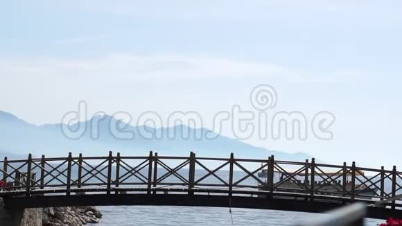 一座可爱的桥后面有一艘小船缓慢地漂浮在海里视频的预览图