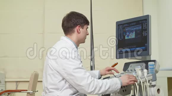 英俊开朗的医生对着镜头微笑拿着超声波扫描仪视频的预览图