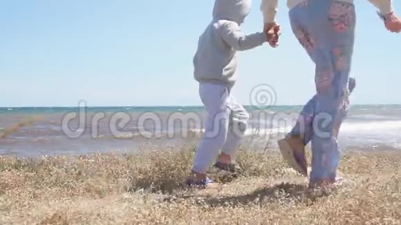 妈妈和儿子手拉手在海边散步视频的预览图