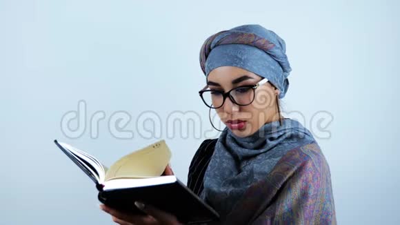 年轻漂亮的阿拉伯商务女性在笔记本上找到必要的信息后惊讶地触摸眼镜视频的预览图