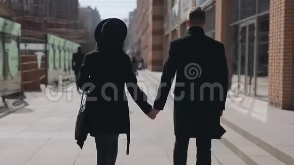 时尚情侣牵着手走在城市大街上后景视频的预览图