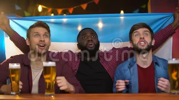 情绪激动的黑人和白种人为阿根廷足球队加油酒吧视频的预览图