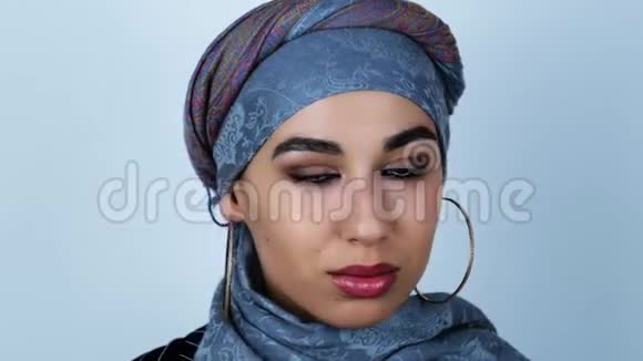 年轻美丽的阿拉伯女人微笑着转过头在孤立的白色背景上意见不合视频的预览图