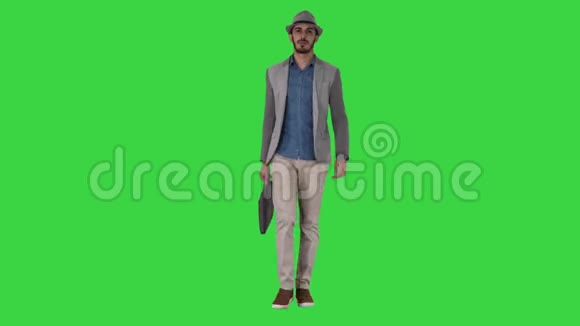 随意的阿拉伯男人戴着帽子带着公文包走在绿色的屏幕上铬钥匙视频的预览图