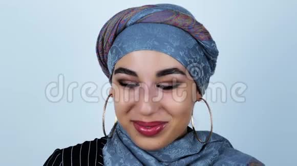 年轻美丽的阿拉伯女人在听到一个孤立的白色背景的滑稽故事后大笑视频的预览图